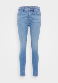 Lyseblå denim skinny jeans med høy midje, fem lommer og en klassisk knapp- og glidelåslukking. Har falming og en glatt tekstur.
