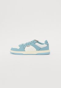 Sneaker azzurri chiari con dettagli bianchi, caratterizzati da una tomaia testurizzata, design con lacci e suola in gomma. Nome del marchio "Hugo" visibile sul tallone e sul lato.
