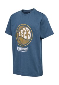Blauwe katoenen t-shirt met een grafische afbeelding van een basketbal, "1923" in het wit, met daaronder de tekst "hummel sportswear" in het wit. Korte mouwen, ronde hals.