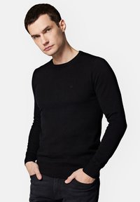 Czarny, dziany sweter z okrągłym dekoltem, dopasowany krój i ściągacze. Prosty design bez wzorów i elementów metalowych.