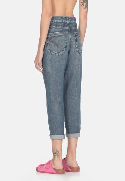Jeans in denim blu con vestibilità rilassata, orli arrotolati e design a cinque tasche. Presentano un leggero sbiadimento e cuciture a contrasto. Abbinati a sandali rosa.