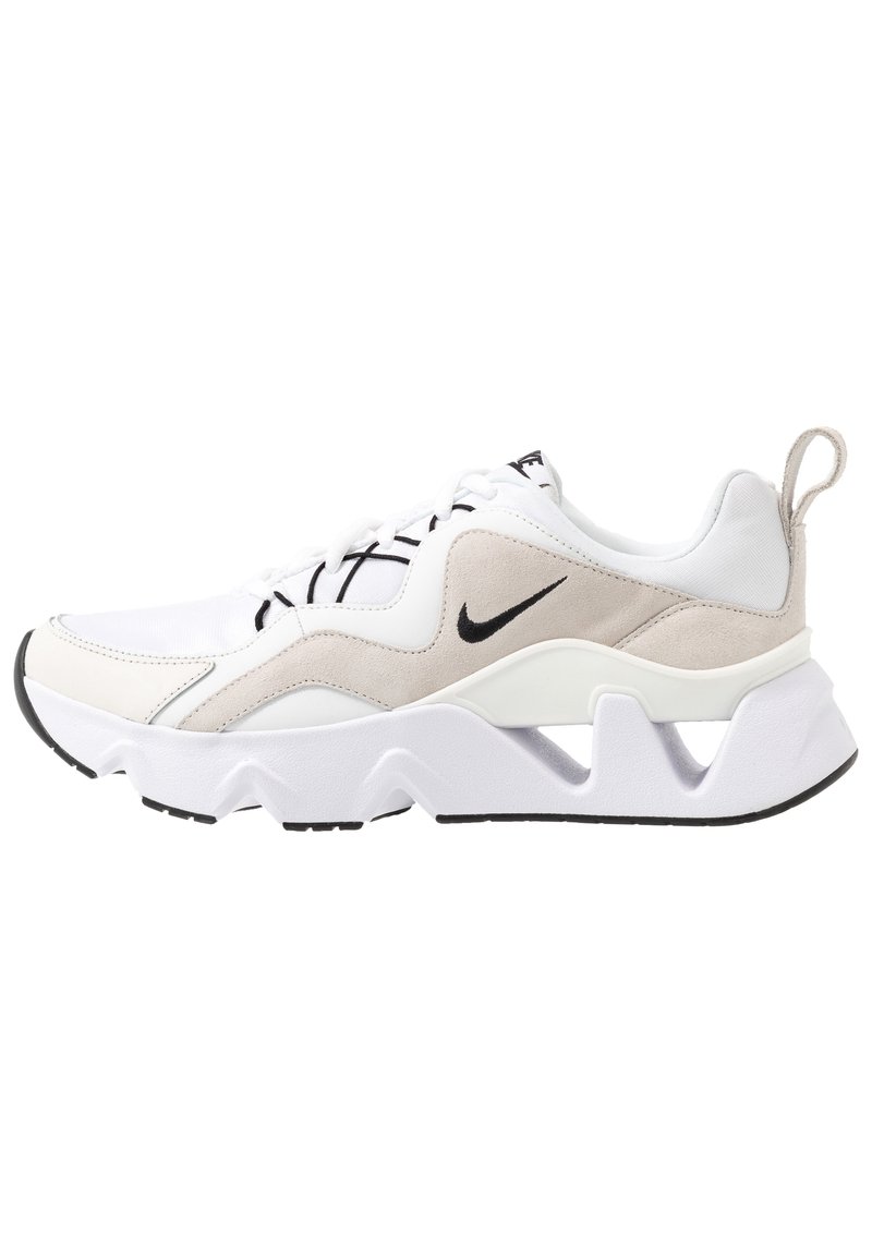 Valkoinen urheilukenkä beigeillä yksityiskohdilla, teksturoitua mokkaa ja synteettisiä materiaaleja, jossa on paksu pohja ja musta logo.