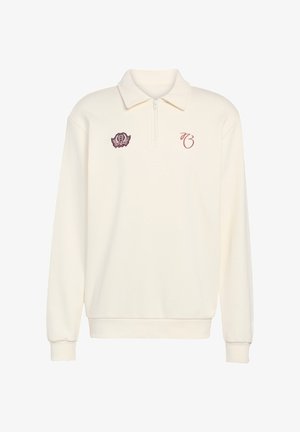 Cremefarvet polo-sweatshirt med lynlåslukning ved kraven, ribstrikkede manchetter og bordeauxfarvede broderede detaljer inklusive et logo og initialer.