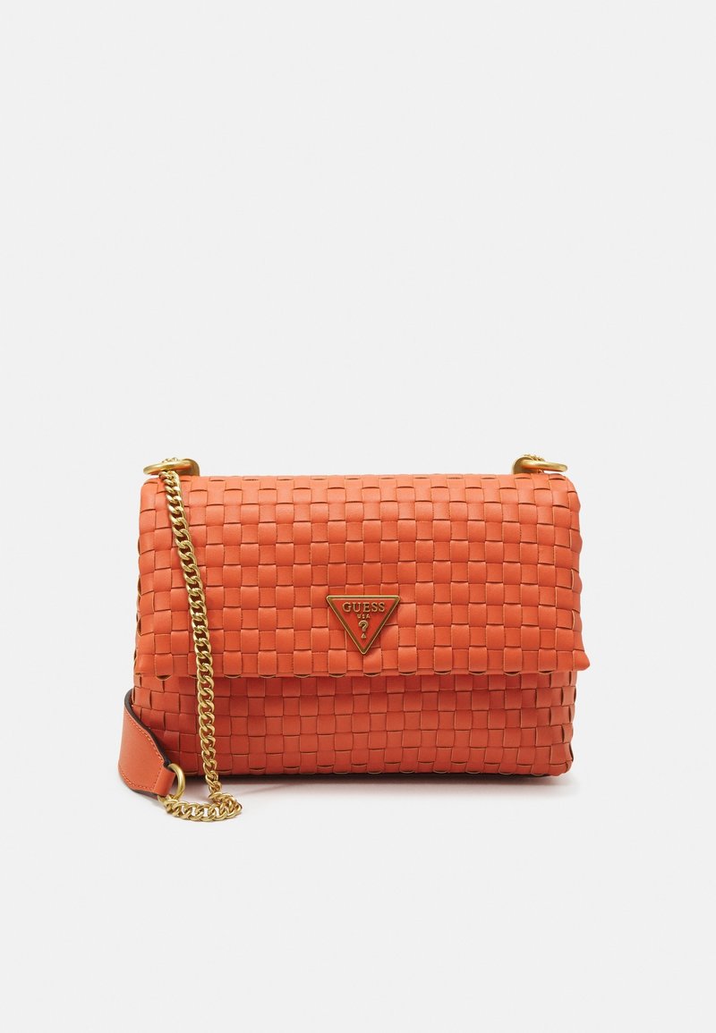 Sac bandoulière en cuir orange tissé avec anse chaîne dorée et plaque triangulaire du logo GUESS sur le rabat avant.