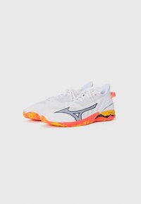 Weiße Sportschuhe mit einem Obermaterial aus Mesh, orange-gelber Sohle, schwarzen Akzenten und einer roten Fersenschlaufe. Merkmale sind eine Schnürung und eine strukturierte Sohle.