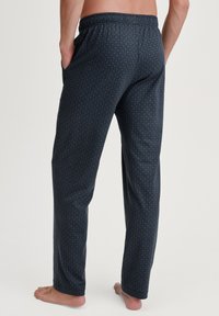 Navy blauw pyjamabroek met een geometrisch patroon, elastische tailleband, zijzakken en een losse pasvorm. Gemaakt van zacht materiaal voor comfort.