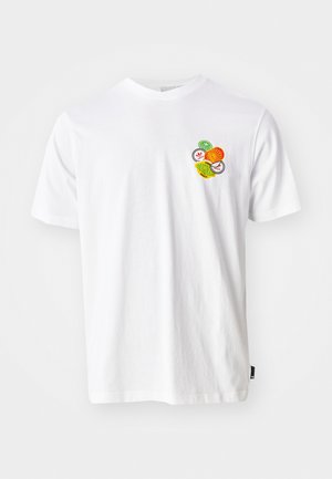 T-shirt en coton blanc avec un graphique rond affichant des motifs de fruits colorés en orange, vert et jaune sur la zone gauche de la poitrine.