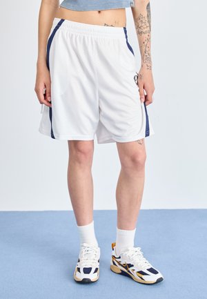 White athletic shorts with navy side stripes, made from lightweight material, featuring an elastic waistband and a textured surface.