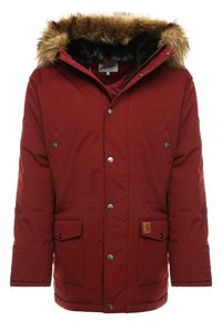 Rode geïsoleerde parka-jack met een faux fur gevoerde kap, drukknoopsluitingen, twee voorzakken en een logopatch op de onderste zak.