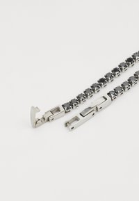 Bracciale in tono argento con accenti di gemma nera, maglie rettangolari e un meccanismo di chiusura per una chiusura sicura.
