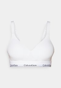 Witte draadloze beha met een diepe V-halslijn. Gemaakt van gladde stof, met een brede elastische band met het ‘Calvin Klein’ logo in zwart.