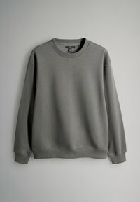 Szara bluza wykonana z miękkiej tkaniny, z okrągłym dekoltem, długimi rękawami oraz ściągaczami na mankietach i dole. Prosty, niezdobiony design.