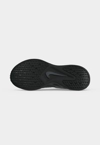 Μαύρη σόλα παπουτσιού Nike με υφασμένο μοτίβο λαβής και το λογότυπο Nike Swoosh στο κέντρο σε λευκό φόντο.