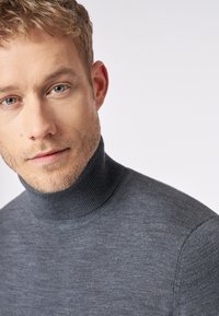 Grijze coltrui met een ribbelige halslijn, met een gladde textuur en een aansluitend ontwerp dat zich vormt naar het lichaam.