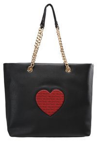 Svart läder toteväska med en framträdande röd hjärtapplikation med upprepad text och gyllene kedjestroppar för extra detalj.