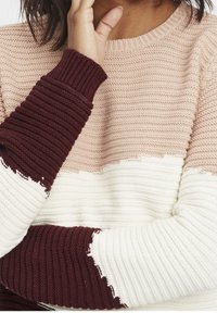 Sweter dziergany z teksturowanym wzorem w poziome paski w kolorach beżowym, kremowym i burgundowym. Rękawy wykończone prążkowanymi mankietami.