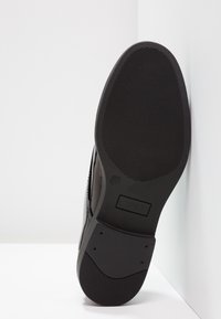 Semelle de chaussure noire avec texture antidérapante, taille 37, et nom de la marque "ONLY" estampé au milieu de la voûte.