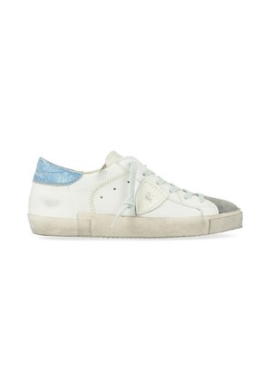 Sneaker bianca basse con linguetta sul tallone blu, paraurti grigio, patch logo laterale e lacci azzurri su suola beige consumata.