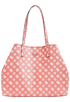 Torba typu tote w kolorze koralowo-różowym z długimi cienkimi uchwytami, pokryta białymi geometrycznymi i kwiatowymi wzorami, z małym metalowym logo Guess na środku.