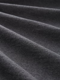 Tela gris con una textura suave, que presenta pliegues sutiles y tonos variados, elaborada con un material blando que parece ligero.
