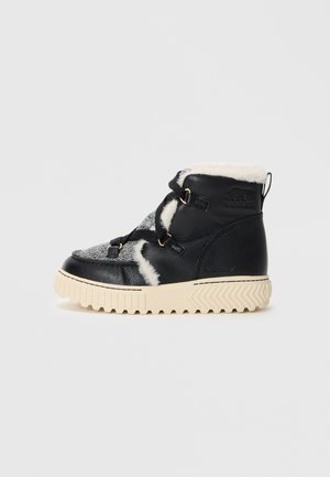 Black waterproof ankle boot with textured gray panel, white faux fur lining, and beige rubber sole featuring a zigzag tread pattern.