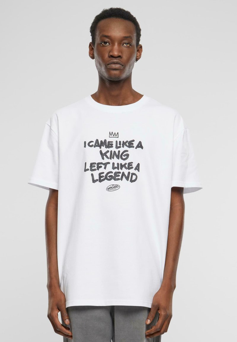 T-shirt en coton blanc à manches courtes avec du texte noir : "JE SUIS VENU COMME UN ROI, JE SUIS PARTI COMME UNE LÉGENDE" et un petit logo en dessous.