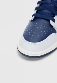 Δερμάτινα αθλητικά παπούτσια με μπλε σκούρο μύτη και γλώσσα, ανοιχτό μπλε πλαϊνές πάνελ κ�αι διάτρητες λεπτομέρειες. Λευκή μεσαία σόλα με υφή στον πάτου.