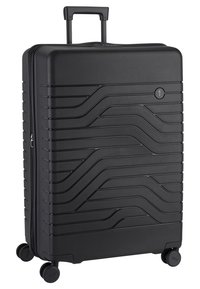 Valigia rigida nera con una texture ondulata, manico retrattile, chiusura a zip e quattro ruote per la mobilità. Presenta un logo circolare.