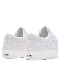 Beige velúr sportcipők sima fehér bőr swoosh-al és fehér gumitalppal. Jellemzője a logó címke a saroknál és a varrási részletek.