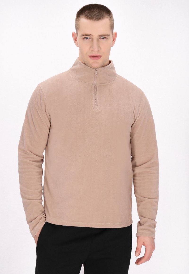 Beige fleece pullover med høj krave, halv lynlås foran, lange ærmer og en glat tekstur. Har en afslappet pasform.