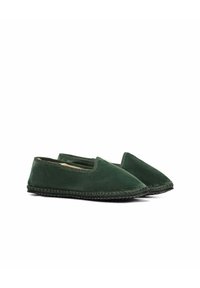 Scarpe slip-on verde in suede con punta arrotondata, superficie testurizzata e cuciture del solo nero a contrasto. Design minimalista, senza hardware o accenti visibili.