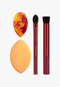 To makeup pensler i rød med bløde børster, en skrå. To svampe: en ensfarvet orange, en marmoreret rød og gul, med en tåreform.