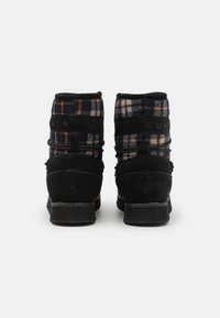 Bottines en daim noir avec un col en textile à carreaux. Dotées d'une tige matelassée et d'une semelle texturée antidérapante. Marque apposée à l'arrière.