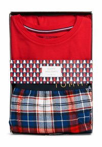 T-shirt rosso a maniche corte con colletto a righe sopra pantaloni da pigiama a quadri blu, in una scatola regalo con un design e un messaggio a tema festivo.