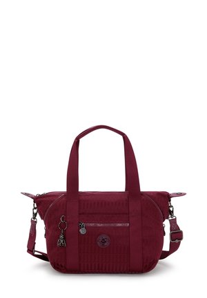 Burgundy handbag with textured material, dual handles, a detachable shoulder strap, and zippered pockets. Features logo and charm accents.