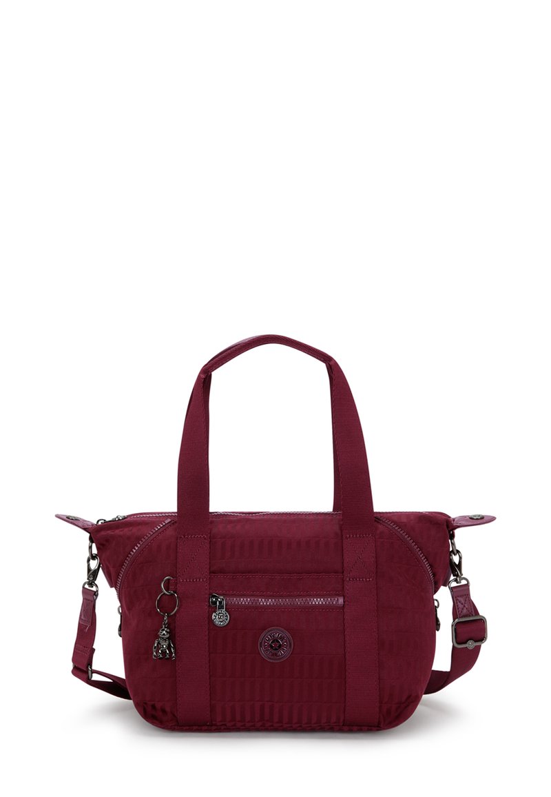 Burgundy handbag with textured material, dual handles, a detachable shoulder strap, and zippered pockets. Features logo and charm accents.