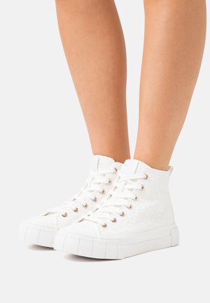 Hvide høj-top sneakers med snøretekstur, udsmykket med gyldne øjer, hvide snørebånd og en kraftig hvid sål.