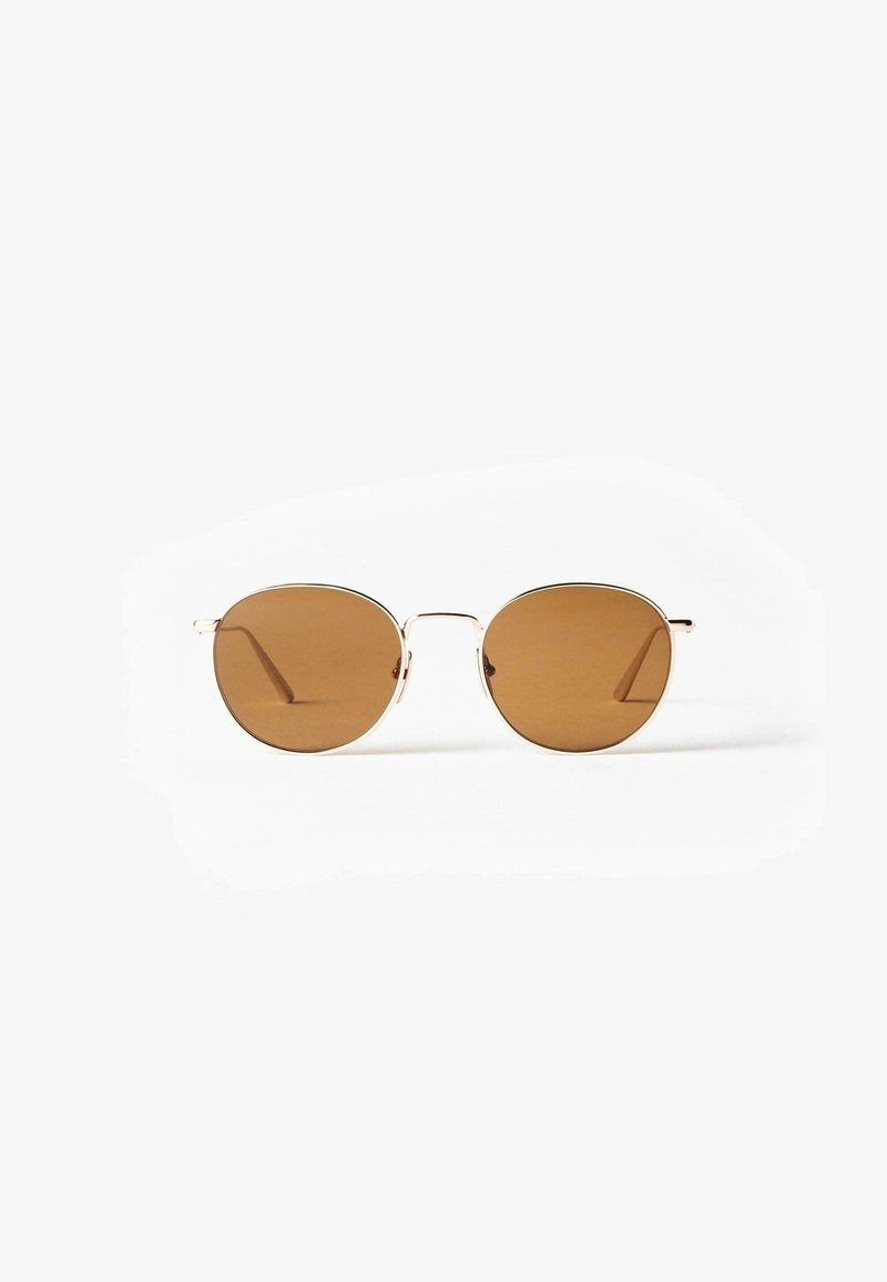 Lunettes de soleil rondes avec des verres marron et des montures en métal doré fines. Le design présente peu de détails et des branches fines.