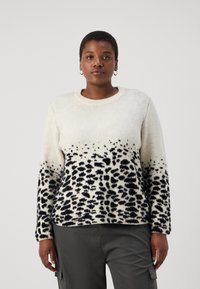 Pletený svetr v krémové vlněné směsi s černým leopardím vzorem. Má kulatý výstřih a dlouhé rukávy. Měkký, texturovaný povrch.