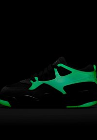Svart sneaker med neongröna accenter, mesh och syntetmaterial, låg profil och svarta snören mot en mörk bakgrund.
