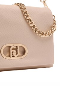 Borsa a mano in pelle beige con finitura testurizzata, dotata di tracolla a catena color oro e una grande fibbia ovale con dettaglio logo.