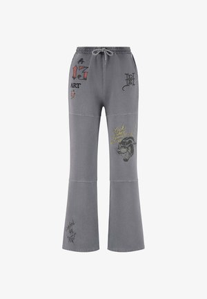 Pantalones gris de campana con cintura elástica, que presentan diversos gráficos y textos bordados en colores contrastantes en las piernas.