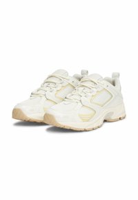 Scarpe sportive bianche realizzate con materiali in rete e sintetici, dotate di una suola testurizzata, punta rinforzata e accenti gialli sottili sui lati.