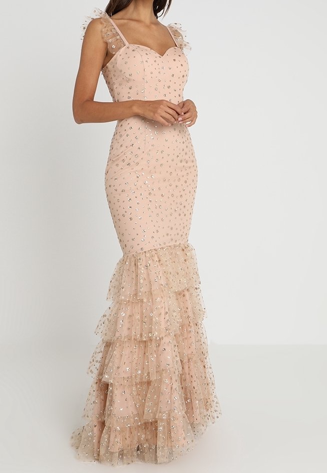 Robe ajustée rose blush avec accents scintillants, bretelles transparentes à volants et jupe en tulle à volants superposés s'étendant jusqu'au sol.