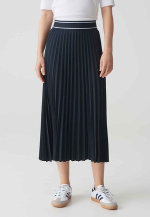Navy pleated midi skirt with a textured fabric, featuring a contrasting white waistband. Paired with white sneakers and blue accents.