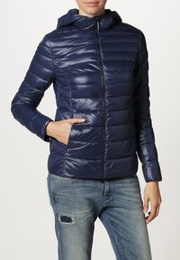 Granatowa pikowana kurtka puchowa z kapturem, z poziomym przeszyciem, przednim zamkiem błyskawicznym i bocznymi kieszeniami. Gładki, błyszczący materiał.