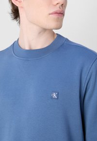 Calvin Klein Jeans EMBRO BADGE CREW NECK - Sudadera - blue coast