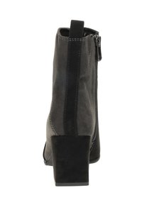 Bottine en suède noire avec un talon carré, dotée d'une fermeture éclair sur le côté et d'une couture contrastante le long des coutures. Texture lisse dans l'ensemble.