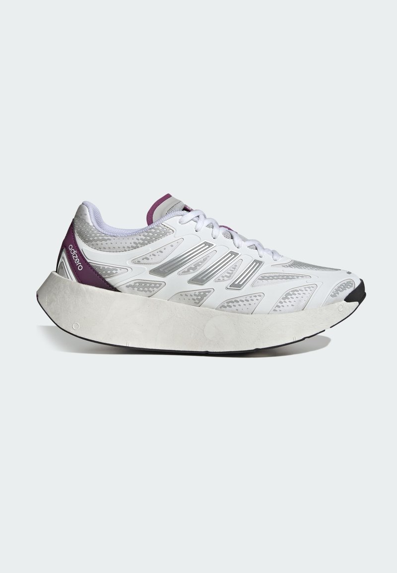 Chaussure de sport blanche avec une tige en maille texturée, des accents argentés, un talon violet et des détails de dentelle, et une semelle de coussin épaisse et courbée en blanc.