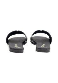 Chanclas planas negras con un diseño minimalista, que presentan dos correas y una plantilla suave y texturizada. Sin logotipos visibles en el exterior.